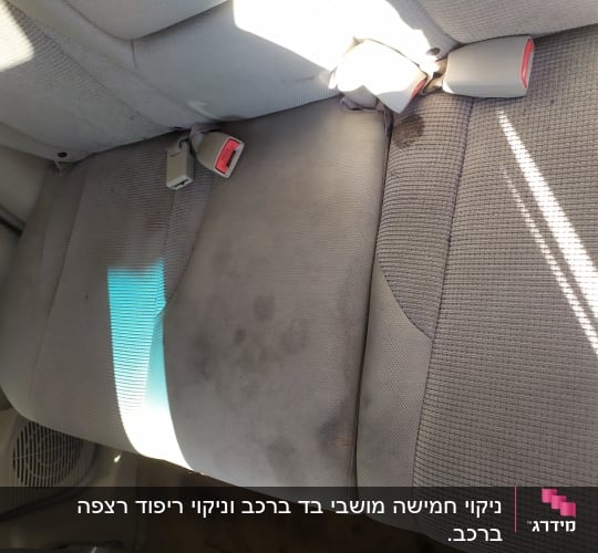מושב רכב עם כתמים כהים על הבד האפור